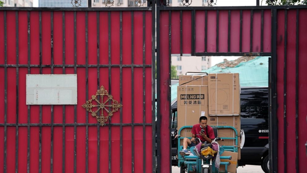 A delivery man transports home appliances from a delivery hub in Beijing, Monday, Aug. 15, 2022. China’s central bank trimmed a key interest rate Monday to shore up sagging economic growth at a politically sensitive time when President Xi Jinping is 