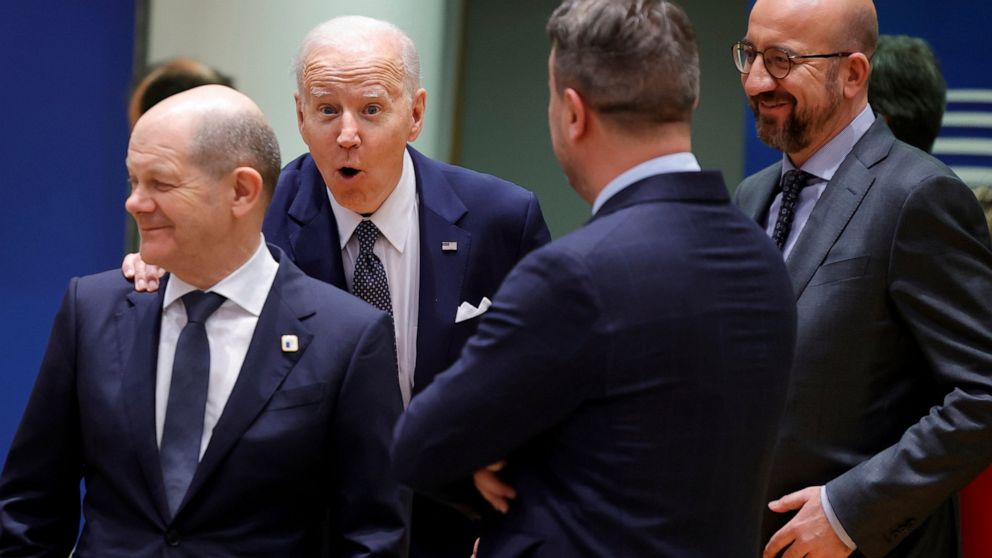 U.S. President Joe Biden, second left, touches the shoulder of German Chancellor Olaf Scholz, left, as they arrive for a round table meeting at an EU summit in Brussels, Thursday, March 24, 2022. As the war in Ukraine grinds into a second month, Pres