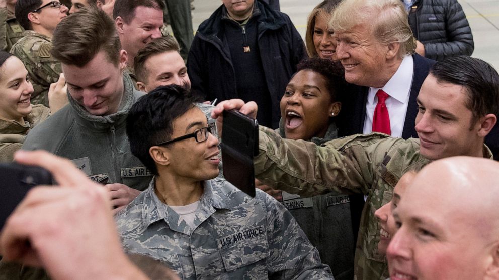 FILE - In this Thursday, Dec. 27, 2018 file photo, President Donald Trump, center right, and first lady Melania Trump, center left, greet members of the military at Ramstein Air Base, Germany. After more than a year of thinly veiled threats that the 