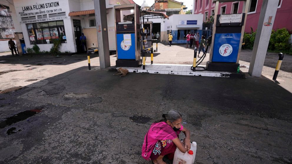 A Sri Lankan woman waits in a deserted gas station, hoping to buy kerosene oil for cooking in Colombo, Sri Lanka, Thursday, May 26, 2022. Sri Lankans for months have been forced to stand in long lines to buy scarce essentials, with many returning hom