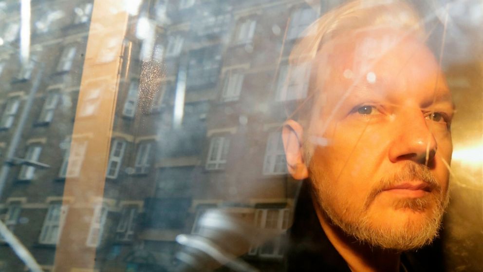 FILE - Buildings are reflected in the window as WikiLeaks founder Julian Assange is taken from court, where he appeared on charges of jumping British bail seven years ago, in London, Wednesday May 1, 2019. Assange has appealed against the British's g
