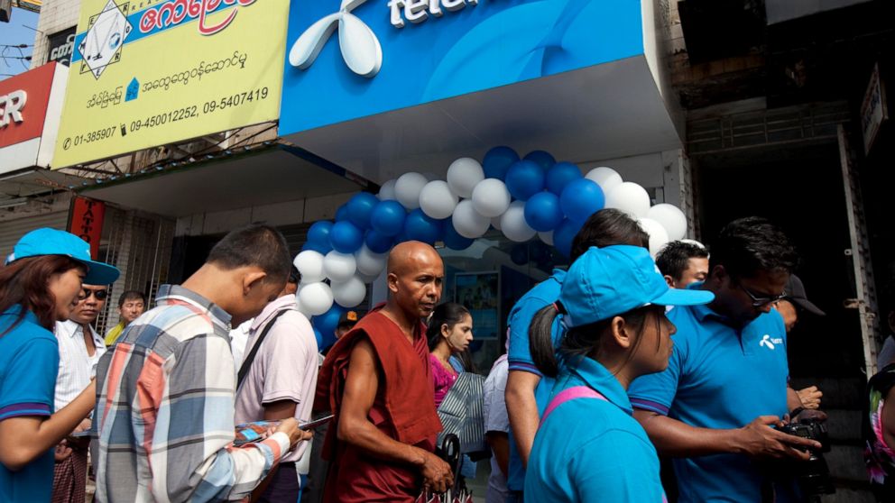 FILE - In this Oct. 26, 2014, file photo, customers line up outside a showroom to buy SIM cards at Telenor, Norwegian telecommunication company, in Yangon, Myanmar. A customer of Telenor's Myanmar telecommunications business has filed a complaint Mon