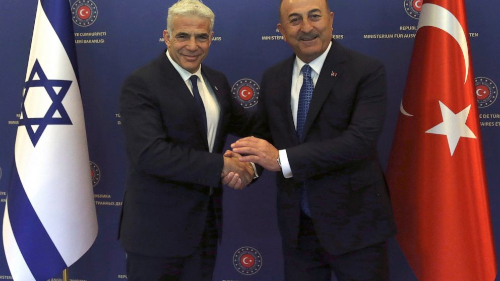 FILE - Turkish Foreign Minister Mevlut Cavusoglu, right, and Israeli Foreign Minister Yair Lapid pose for photos before their talks, in Ankara, Turkey, June 23, 2022. Israel and Turkey will restore full diplomatic relations and dispatch ambassadors f