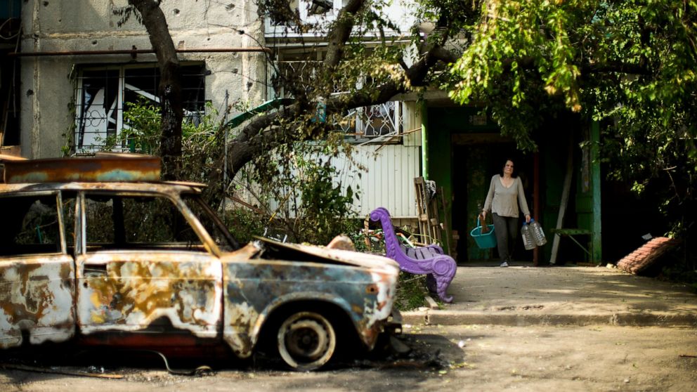 Olena Voutenko leaves her home in a building damaged in an overnight missile strike in Sloviansk, Ukraine, Tuesday, May 31, 2022. (AP Photo/Francisco Seco)
