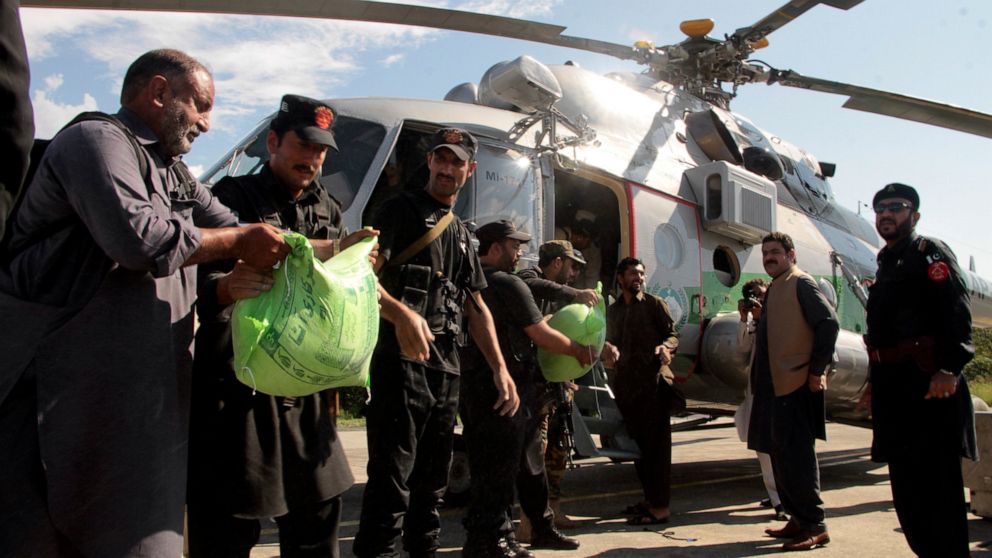 Frontier constabularies load food to a helicopter for flood-affected people, in Swat valley, Pakistan, Sunday, Aug. 28, 2022. International aid for flood victims has started arriving in Pakistan, as military helicopters, troops and rescuers evacuated