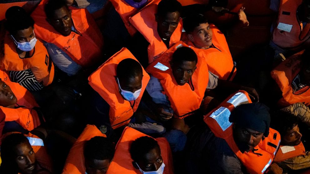 Migrants rescued by the Spanish NGO Open Arms in the Mediterranean sea huddle in a boat early Sunday, Sept. 18, 2022. Around 200 migrants from Syria and Africa countries were rescued by NGO Open Arms crew members. (AP Photo/Petros Karadjias)