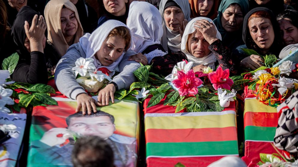 Syrian Kurds attend a funeral of people killed in Turkish airstrikes in the village of Al Malikiyah , northern Syria, Monday, Nov. 21, 2022. The airstrikes, which Turkey said were aimed at Kurdish militants whom Ankara blamed for a deadly Nov. 13 bom