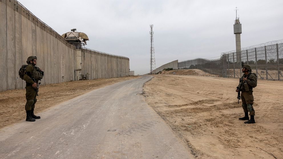 FILE - Israeli soldiers secure the site of a ceremony marking the completion of an enhanced security barrier along the Israel-Gaza border, Tuesday, Dec. 7, 2021. The Israeli military says it is sending additional forces to the area around the Gaza St