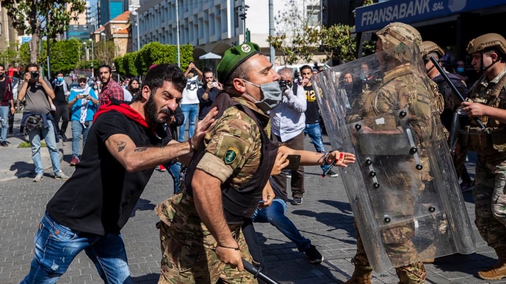 Army soldiers scuffle with anti-government protesters during May Day protests near the Lebanese Central Bank in Beirut, Lebanon, Friday, May 1, 2020. Hundreds rallied outside the country's central bank and in other parts of the country a day after th