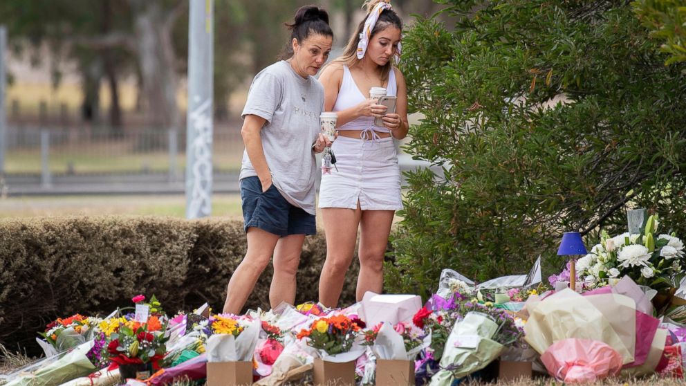 Two women stand at a floral tribute, Friday, Jan. 18, 2019, at the scene where the body of Israeli student Aiia Maasarwe was found earlier in the week in Melbourne, Australia. Maasarwe, a 21-year-old student who had been studying at La Trobe Universi