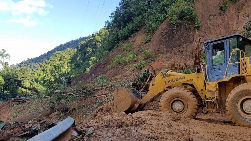 A bulldozer clears out the road damaged by landslide to access a village swamped by another landslide in Quang Nam province, Vietnam on Thursday, Oct. 29, 2020. Typhoon Molave slammed into Vietnam with destructive force Wednesday, sinking two fishing