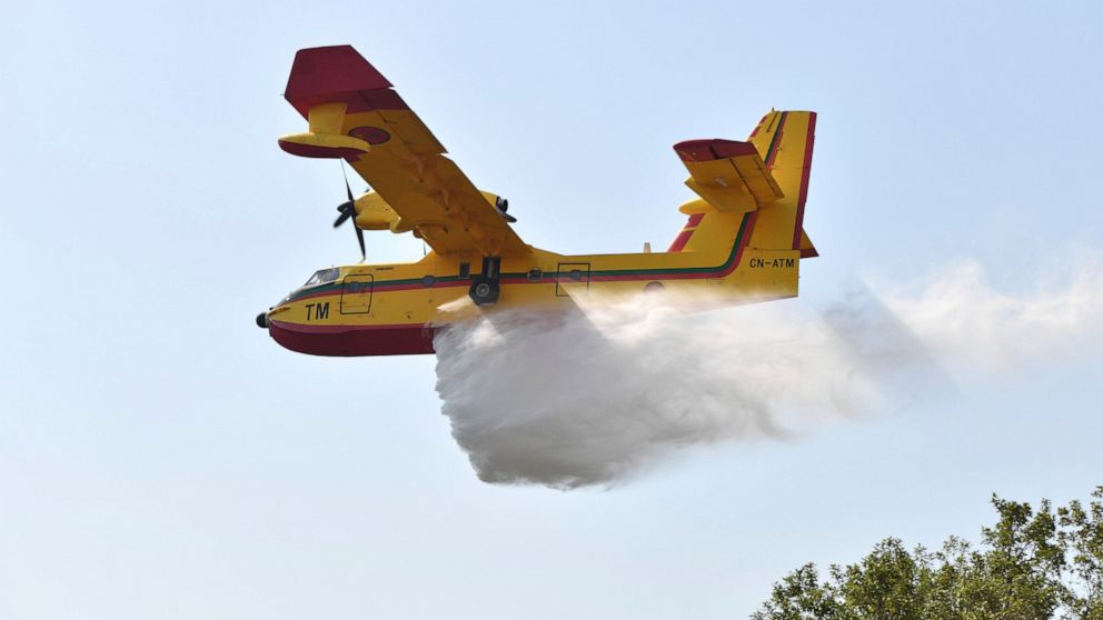 Fire fighting planes drop water to put out a forest blaze in Laarache, northern Morocco, Friday, July 15, 2022. Fires fanned by strong winds and extreme temperatures have spread across hundred of hectares in North Africa since Thursday evening. (AP Photo)
