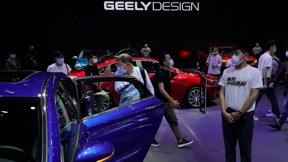 FILE - Visitors look at cars produced by Geely at the Auto China 2020 show in Beijing on Sept. 27, 2020. Renault SA and China's Geely announced plans Tuesday, Nov. 8, 2022 for a jointly owned venture to produce gasoline-powered and hybrid powertrains