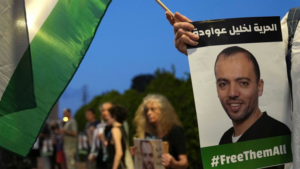 FILE - Protesters gather outside the hospital where Khalil Awawdeh, pictured in placards, a Palestinian prisoner in Israel is on hunger strike, in Be'er Yaakov, Aug. 13, 2022. Arabic on the placard: "Freedom for Khalil Awawdeh." Ahlam Haddad, Awawdeh
