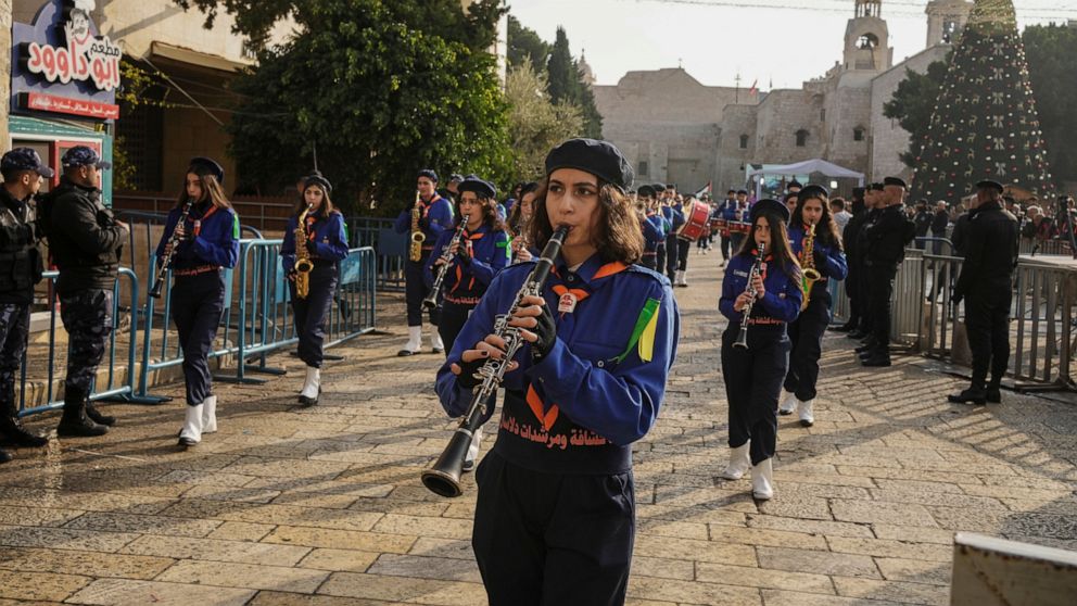 Girls scouts march during Christmas parade in Manger Square, adjacent to the Church of the Nativity, traditionally believed to be the birthplace of Jesus Christ, in the West Bank town of Bethlehem, Saturday , Dec. 24, 2022. (AP Photo/Maya Alleruzzo)
