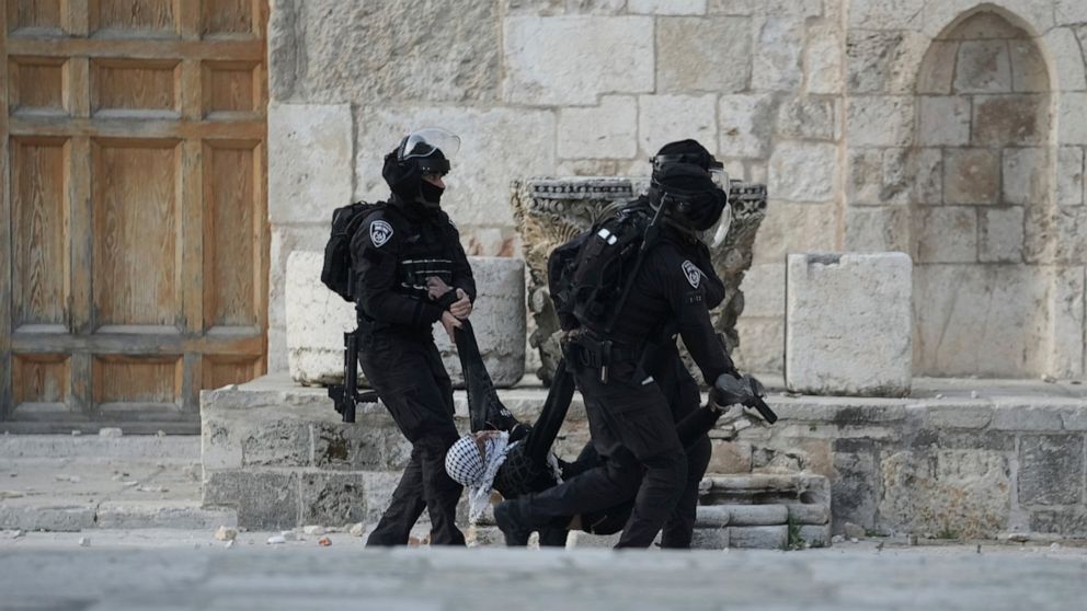 FILE - Israeli police carry a Palestinian protester during clashes at the Al Aqsa Mosque compound in Jerusalem's Old City, on April 22, 2022. The 21-year-old Palestinian man died Saturday, May 14, 2022, from a head wound sustained last month after Is