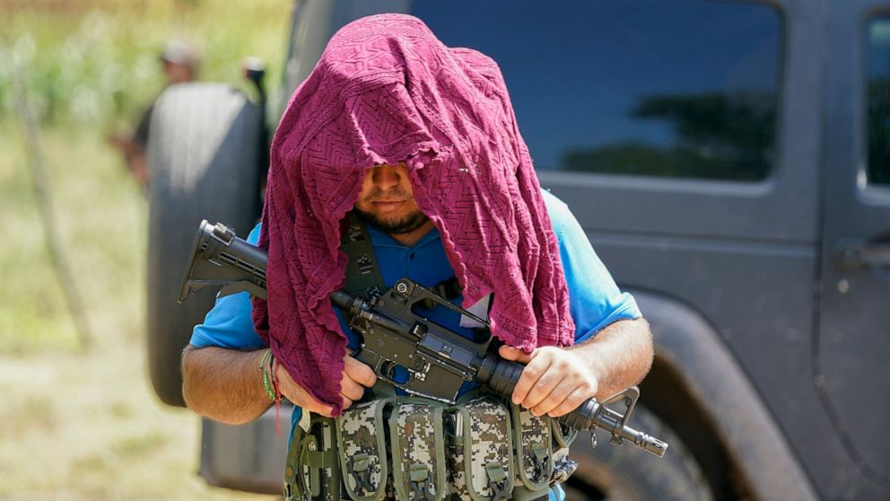 An armed man who claim to be members of a self-defense group patrols the limits of Taixtan in the Michoacan state of Mexico, Thursday, Oct. 28, 2021. The army has largely stopped fighting drug cartels here, instead ordering soldiers to guard the divi