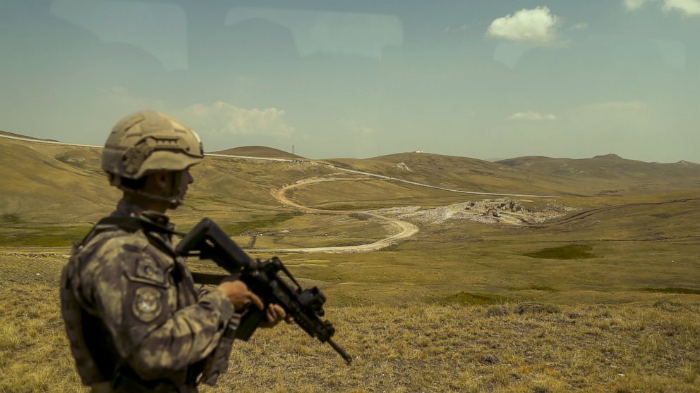 A Turkish soldier patrols the border wall that separates Turkey and Iran, in Van Province, Turkey, Saturday Aug. 21, 2021. The new border wall separating Turkey from Iran covers a third of the 540-kilometer (335-mile) border, leaving plenty of gaps f