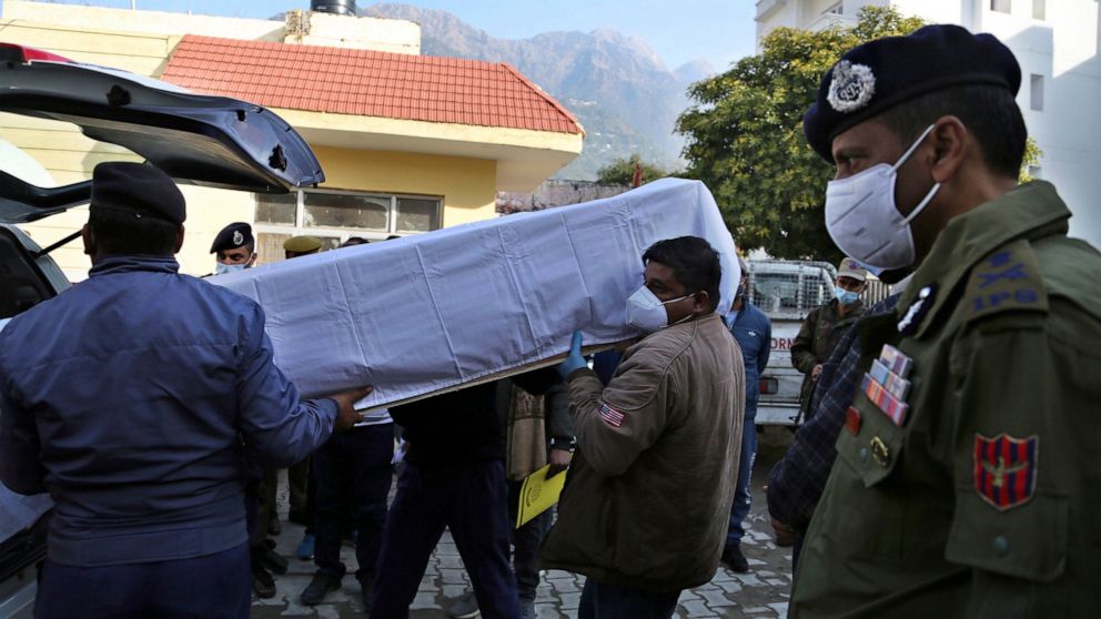 Health workers carry the coffin of a victim, who died in a stampede at the Mata Vaishnav Devi shrine, at a hospital in Katra, India, Saturday, Jan. 1, 2022. A stampede at a popular Hindu shrine in Indian-controlled Kashmir killed at least 12 people a