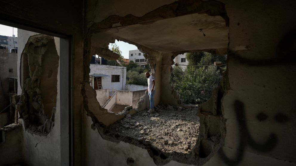 People look at the demolished house of Palestinian gunman Raed Hazem, who carried out a deadly attack in Tel Aviv in April, after it was destroyed by Israeli forces in the West Bank city of Jenin, Tuesday, Sept. 6, 2022. Hazem opened fire into a crow