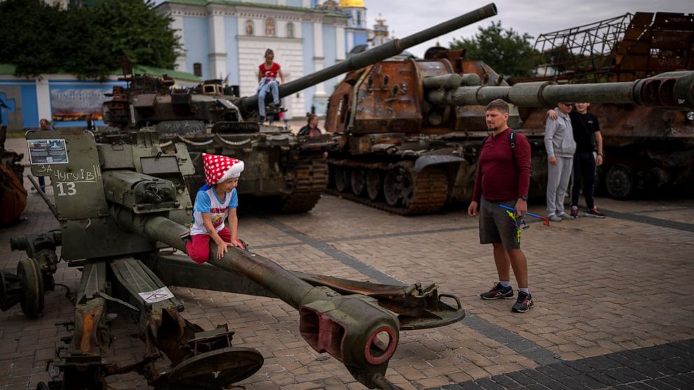 Children play jumping on destroyed Russian military vehicles displayed in central Kyiv, Ukraine, Saturday, Sept. 3, 2022. (AP Photo/Emilio Morenatti)