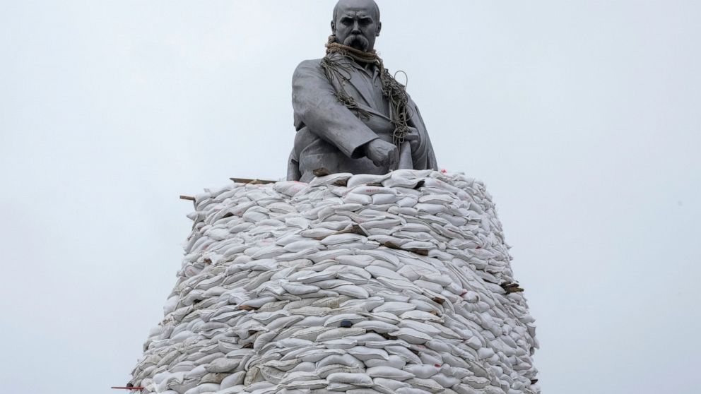 AP PHOTOS: Day 32: Signs of resolve and collective grief