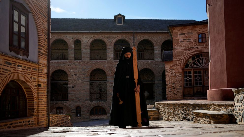 A monk using a mallet and plank to summon monks and visitors to the afternoon prayers, pauses at the Pantokrator Monastery in the Mount Athos, northern Greece, on Thursday, Oct. 13, 2022. Deep inside a medieval fortified monastery in the Mount Athos 