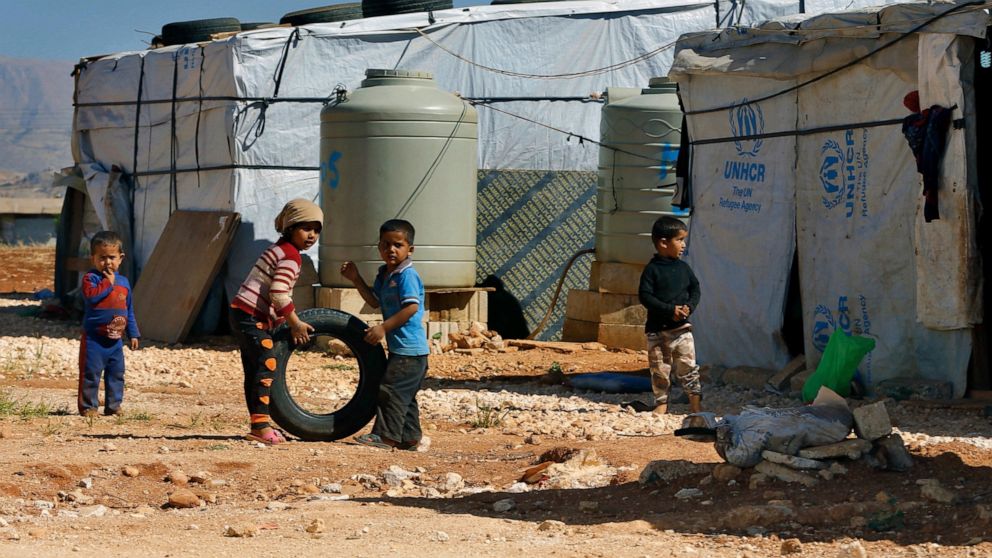 FILE - In this June 20, 2017 file photo, Syrian refugee children play outside their family tents at a Syrian refugee camp in the eastern city of Baalbek, Lebanon. The U.N. agency for Palestinian refugees said Wednesday, April 22, 20202, that a Palest