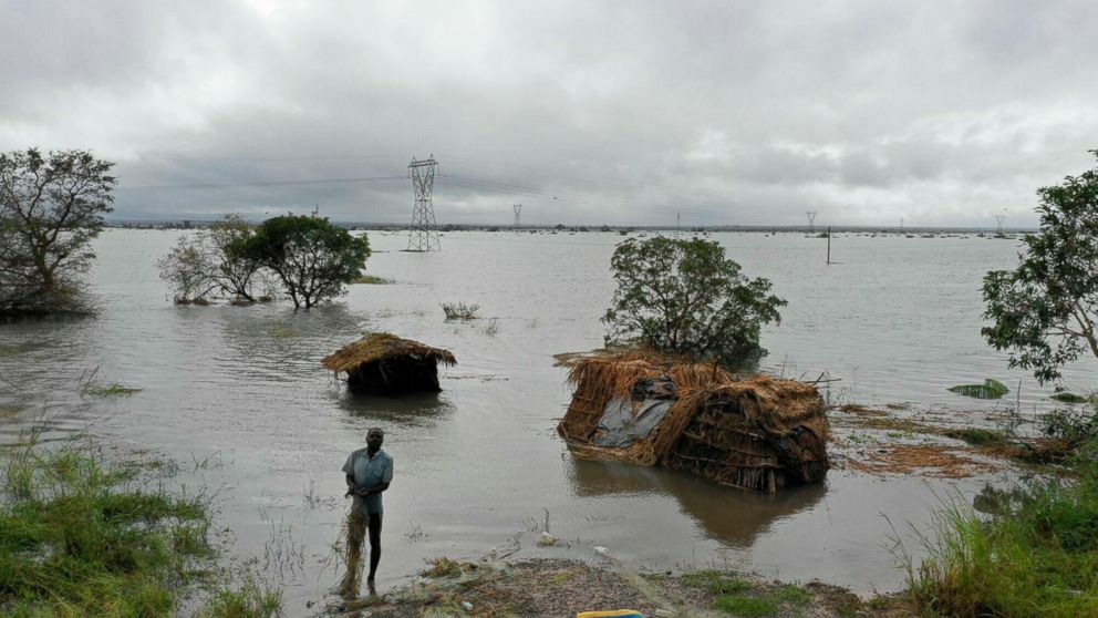 A man stands in flood waters following cyclone force winds and heavy rain near the coastal city of Beira, Mozambique, Wednesday March 20, 2019. Torrential rains were expected to continue into Thursday and floodwaters were still rising, according to a