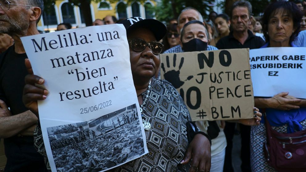 A woman holds up a banner that reads: "Melilla, a well-resolved massacre", during one of many protests across Spain amid for the investigation over the deaths of at least 23 people at the border between the Spanish enclave of Melilla and Morocco, in 