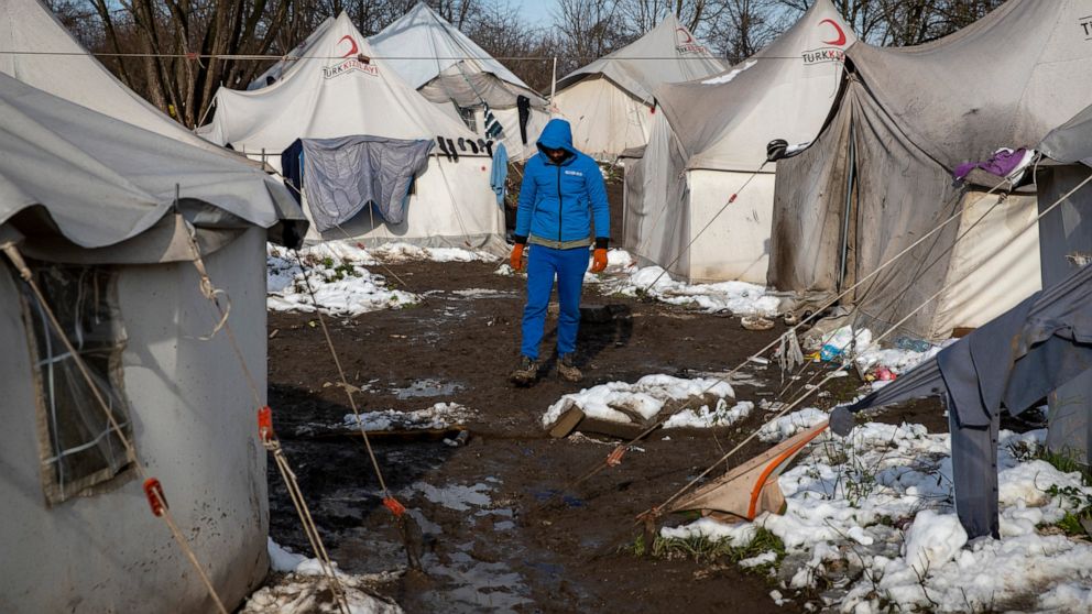 FILE --A migrant walks between tents at the Vucjak refugee camp outside Bihac, northwestern Bosnia, Friday, Dec. 6, 2019. Despite calls for their relocation before winter, hundreds of migrants remain stuck at a make-shift tent camp in northwestern Bo