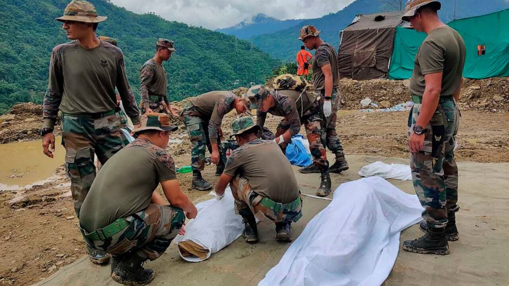 Soldiers wrap bodies of victims of a mudslide in Noney, northeastern Manipur state, India, Friday, July 1, 2022. Rescuers found more bodies Friday as they resumed searching for dozens of missing after a mudslide triggered by weeks of heavy downpours 