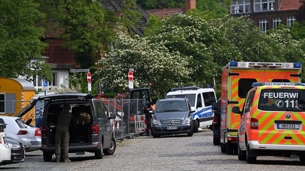 Police and emergency forces stand near a school in Bremerhaven, Germany, Thursday, May 19, 2022. German police say they have detained a suspect in connection with an attack at a high school in the northern city of Bremerhaven in which one person was 