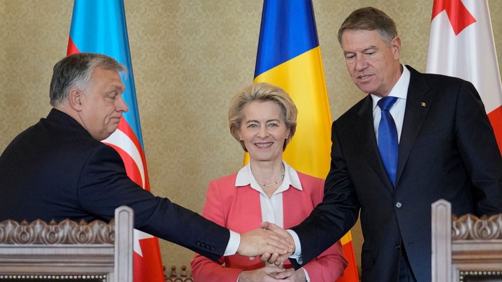 Hungarian Prime Minister Viktor Orban shakes hands with Romanian President Klaus Iohannis as European Commission President Ursula von der Leyen smiles at the Cotroceni presidential palace in Bucharest, Romania, Saturday, Dec. 17, 2022. The leaders of