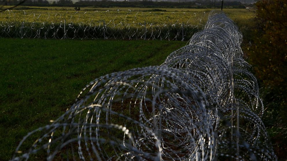 Razor wire is seen along the southern side of a U.N buffer zone that cuts across the ethnically divided Cyprus, near village of Astromeritis, Tuesday, March 9, 2021. The government of ethnically split Cyprus has come under fire over a decision to lay