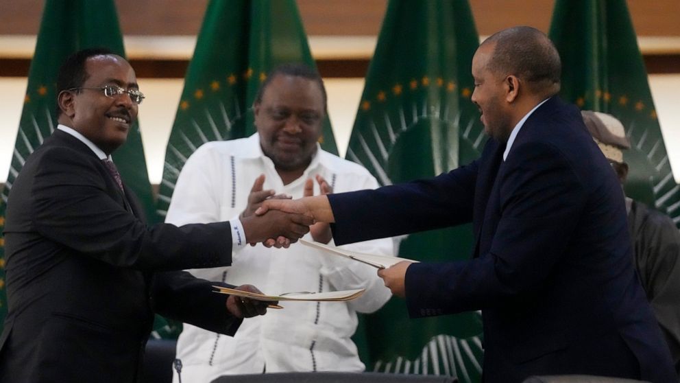 Lead negotiator for Ethiopia’s government, Redwan Hussein, left, shakes hands with lead Tigray negotiator Getachew Reda, as Kenya's former president, Uhuru Kenyatta looks on, after the peace talks in Pretoria, South Africa, Wednesday, Nov. 2, 2022. E