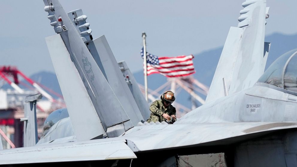 U.S. soldier checks the F/A-18 Super Hornet fighter jet on the deck of the nuclear-powered aircraft carrier USS Ronald Reagan in Busan, South Korea, Friday, Sept. 23, 2022. The nuclear-powered aircraft carrier USS Ronald Reagan arrived in the South K