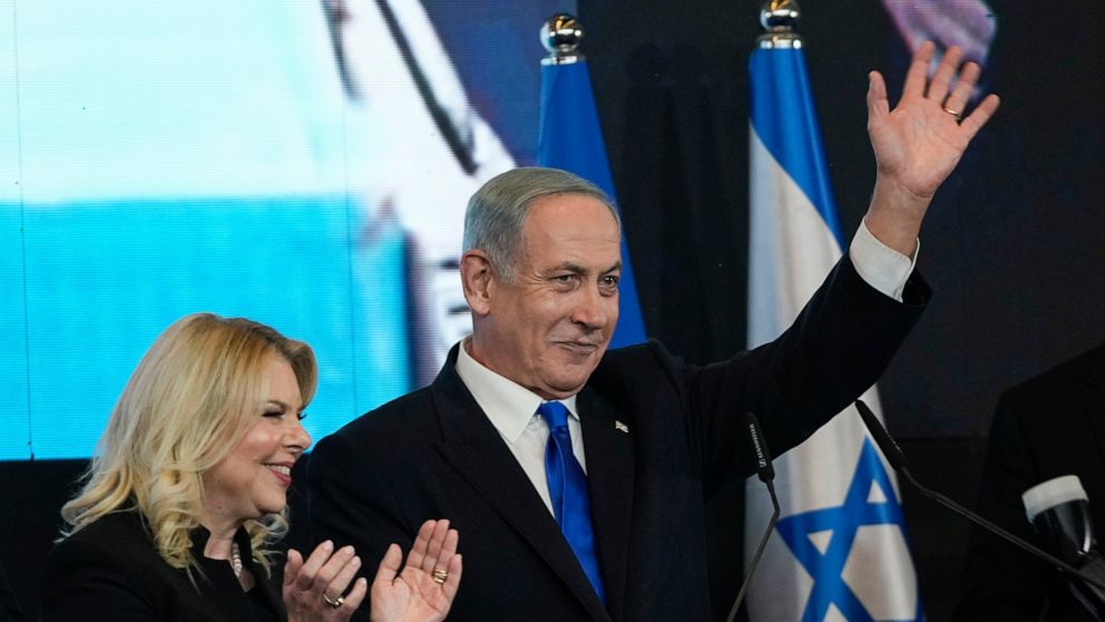 Benjamin Netanyahu, former Israeli Prime Minister and the head of Likud party, accompanied by his wife Sara waves to his supporters after first exit poll results for the Israeli Parliamentary election at his party's headquarters in Jerusalem, Wednesd
