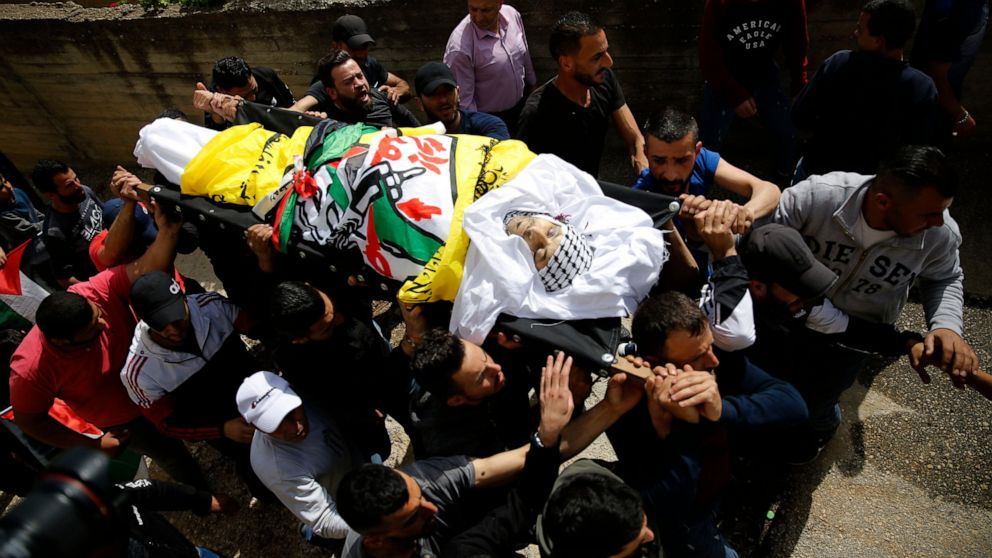 Palestinians carry the body of Osama Mansour during his funeral, in the village of Biddu near the West Bank city of Ramallah, Tuesday, April 6, 2021. Mansour was killed by Israel soldiers at a temporary vehicle checkpoint in the occupied West Bank ne