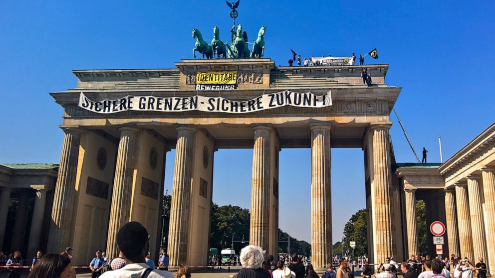 FILE - In this Aug. 27, 2016 file photo, activists of the Identitarian Movement protest on the Brandenburg Gate in Berlin, Germany, with a banner reading 'secure borders - secure future'. The German domestic intelligence agency says it is stepping up