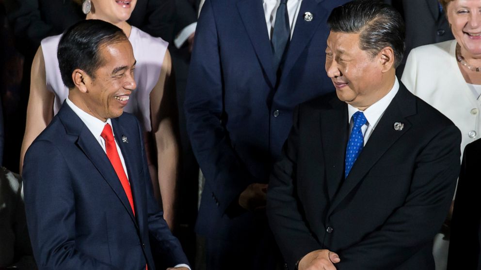 FILE - Indonesia's President Joko Widodo, left, speaks to China's President Xi Jinping during a family photo session in front of Osaka Castle at the G-20 summit, on June 28, 2019, in Osaka, Japan. President Widodo was heading to Beijing on Monday, Ju