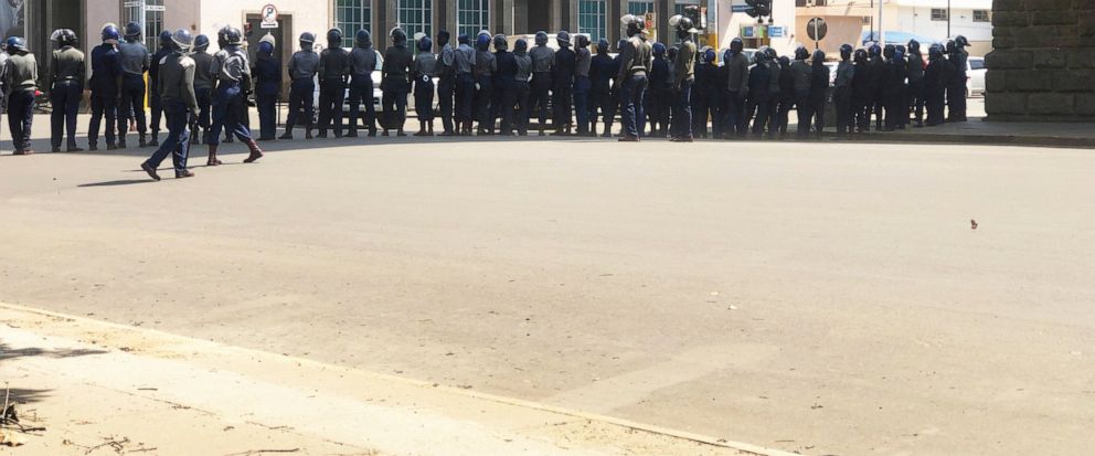 Armed Riot Police block a main road during a patrol on the streets in Harare, Thursday, Aug, 15, 2019. In a show of force to discourage anti government protests, Zimbabwe police with water cannons patrolled the capitals streets and warned residents,