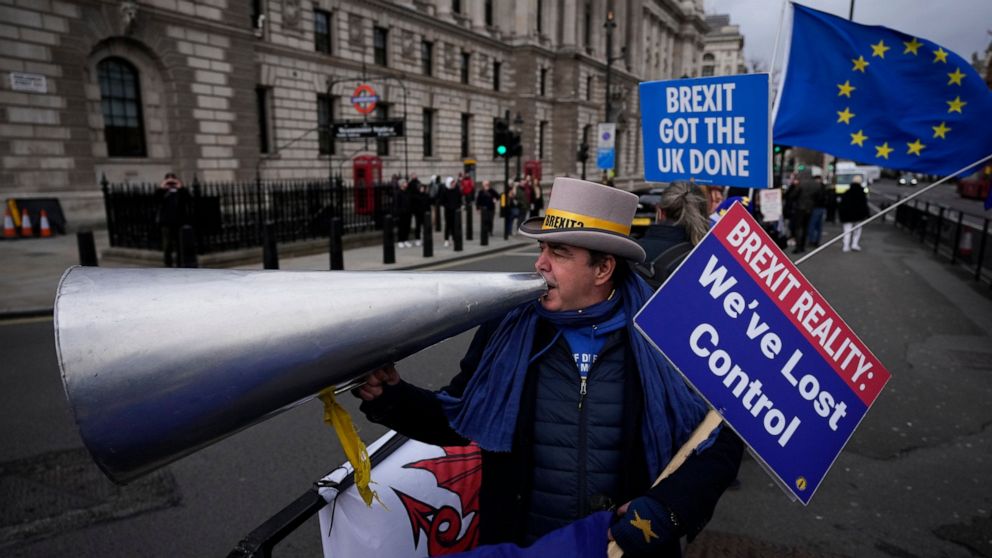 Anti-Brexit protester Steve Bray demonstrates on the edge of Parliament Square across the street from the Houses of Parliament, in London, Wednesday, Dec. 8, 2021. British Prime Minister Boris Johnson on Wednesday ordered an inquiry and said he was "