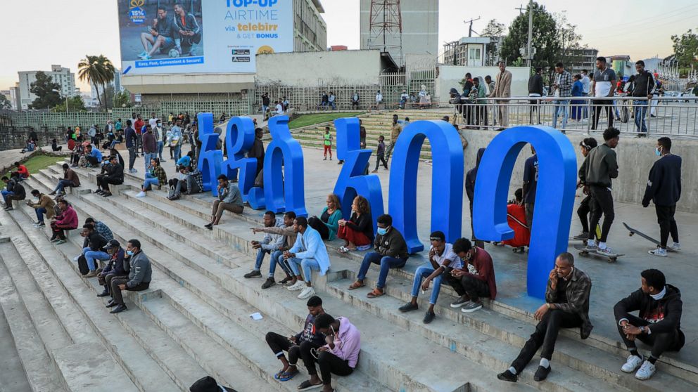 FILE - People sit on steps next to a sculpture in the shape of Amharic words reading "Addis Ababa" in the Piazza old town area of the capital Addis Ababa, Ethiopia Thursday, Nov. 4, 2021. American and British citizens have been swept up in Ethiopia's