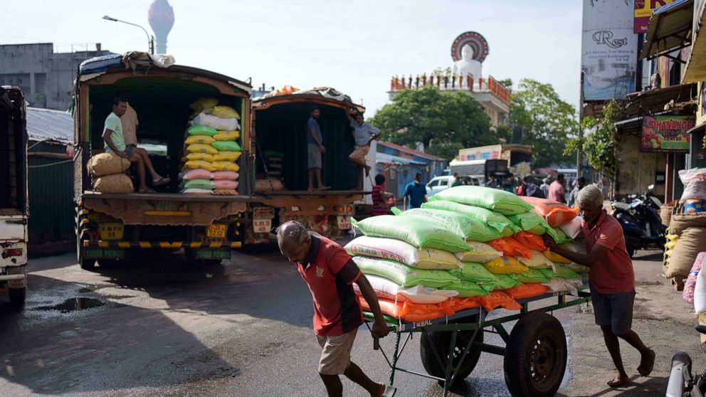 Laborers transport a cart load of rice sacks at a market place in Colombo, Sri Lanka, Monday, Nov. 14, 2022. (AP Photo/Eranga Jayawardena)