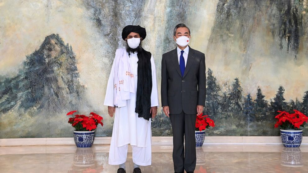 FILE - In this July 28, 2021, file photo released by China's Xinhua News Agency, Taliban co-founder Mullah Abdul Ghani Baradar, left, and Chinese Foreign Minister Wang Yi pose for a photo during their meeting in Tianjin, China. In the U.S. departure 