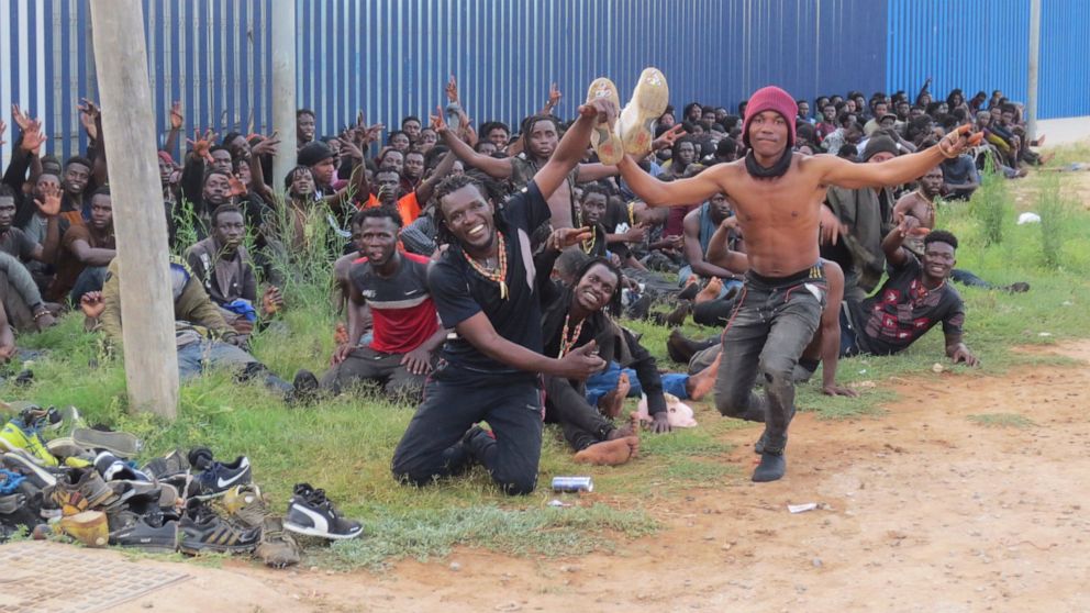 A group of Migrants celebrate at a migrant processing center in Melilla, Spain, Thursday July 22, 2021. Authorities in Spain's autonomous city of Melilla say that 238 African men have made it to the Northern African Spanish enclave after climbing ove