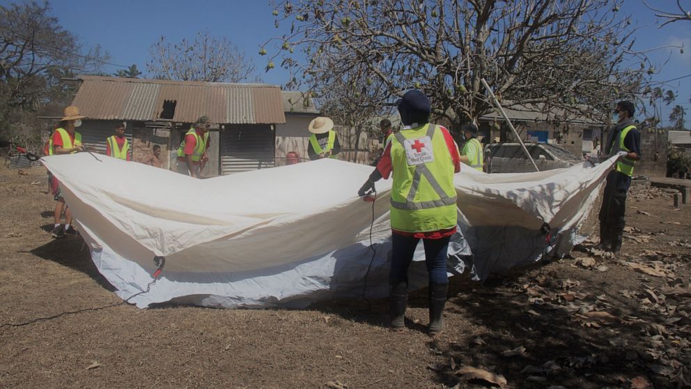 In this photo released by the Tonga Red Cross Society, Red Cross teams set up a temporary shelter in Kanokupolu, western Tongatapu, Friday, Jan. 21, 2022, as the Tonga island group grapples with the aftermath from the recent underwater volcanic erupt