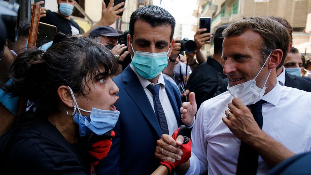 French President Emmanuel Macron listens to a resident as he visits a devastated street of Beirut, Lebanon, Thursday Aug.6, 2020. French President Emmanuel Macron has arrived in Beirut to offer French support to Lebanon after the deadly port blast.(A