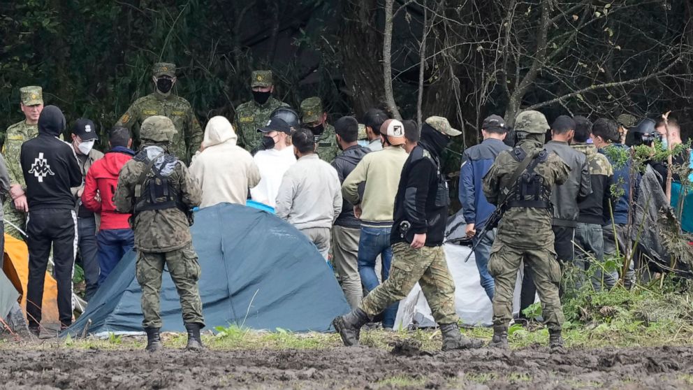 FILE - Polish security forces block migrants on the border with Belarus in Usnarz Gorny, Poland, on Wednesday, Sept. 1, 2021. Poland’s Foreign Ministry says it summoned a Belarusian diplomat over an “intrusion” into Polish territory of “uniformed ind